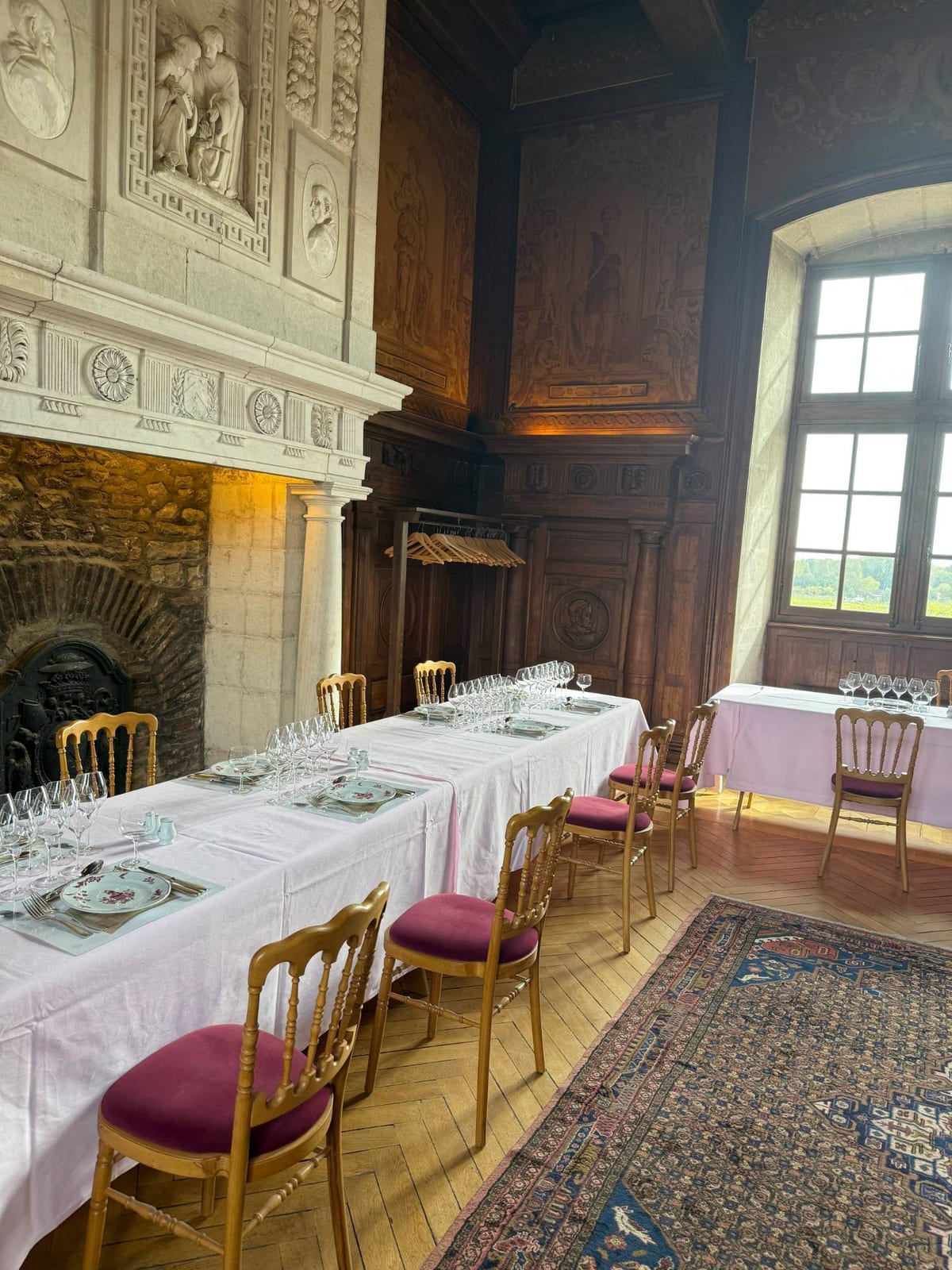 Salle de réception boisée avec cheminée sculptée, tables dressées pour la rencontre en Bourgogne
