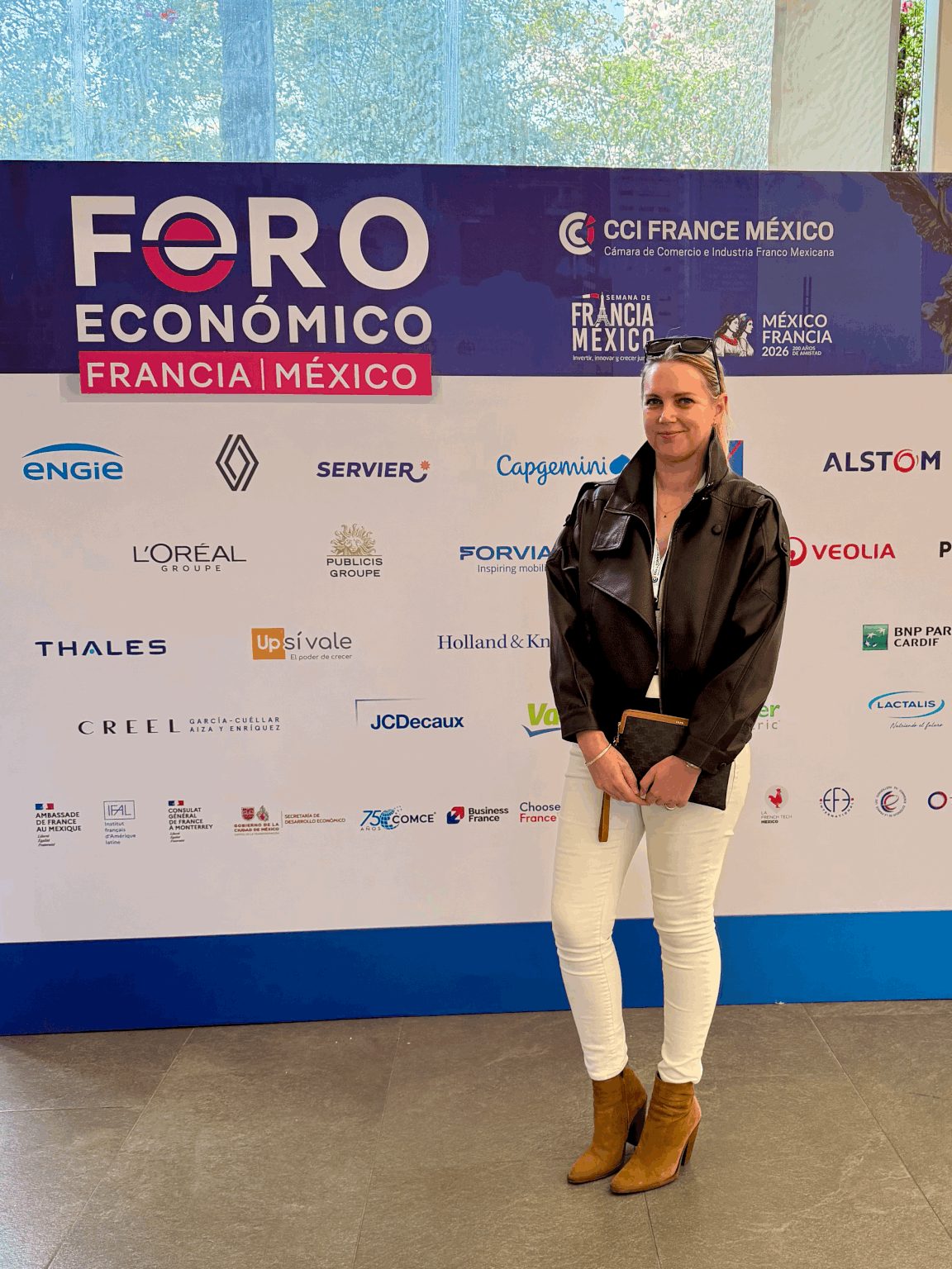 Julie Aubin devant le mur du Forum économique France-Mexique de la CCI France Mexique, à Mexico